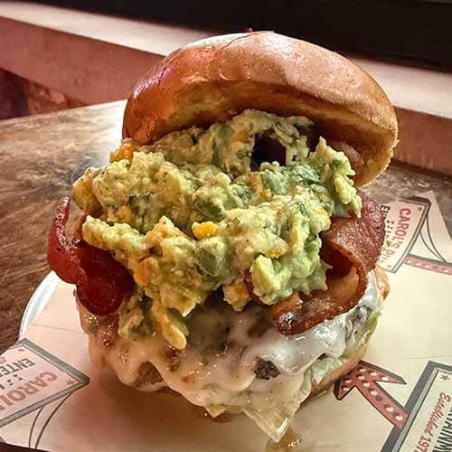 Promotional image for April's Burger of the Month at Carol's Pub: The Guacamole Wrangler Burger